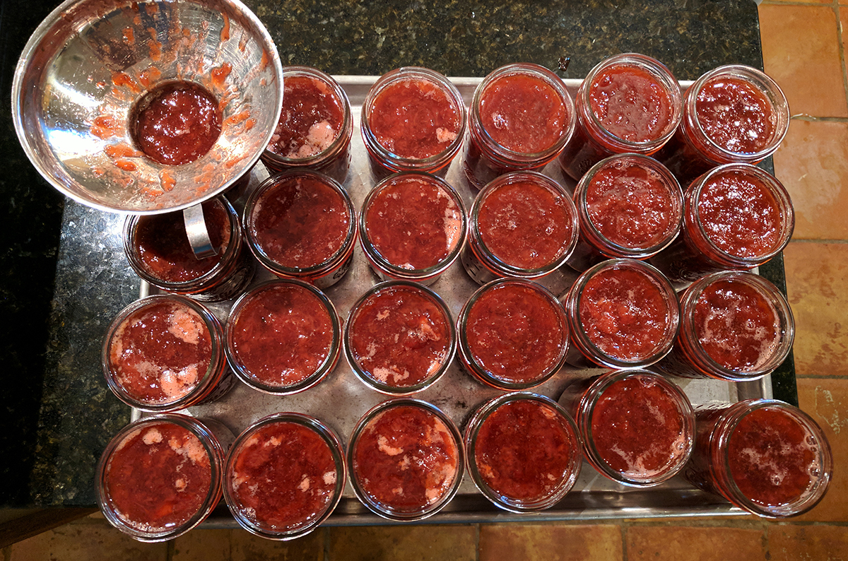 Filling jars with roasted strawberry preserves. 
