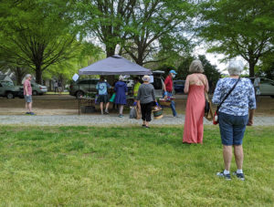 Customers practiced social distancing wile waiting in line for Eco farm veggies at the Fearrington Farmers' Market on opening day.