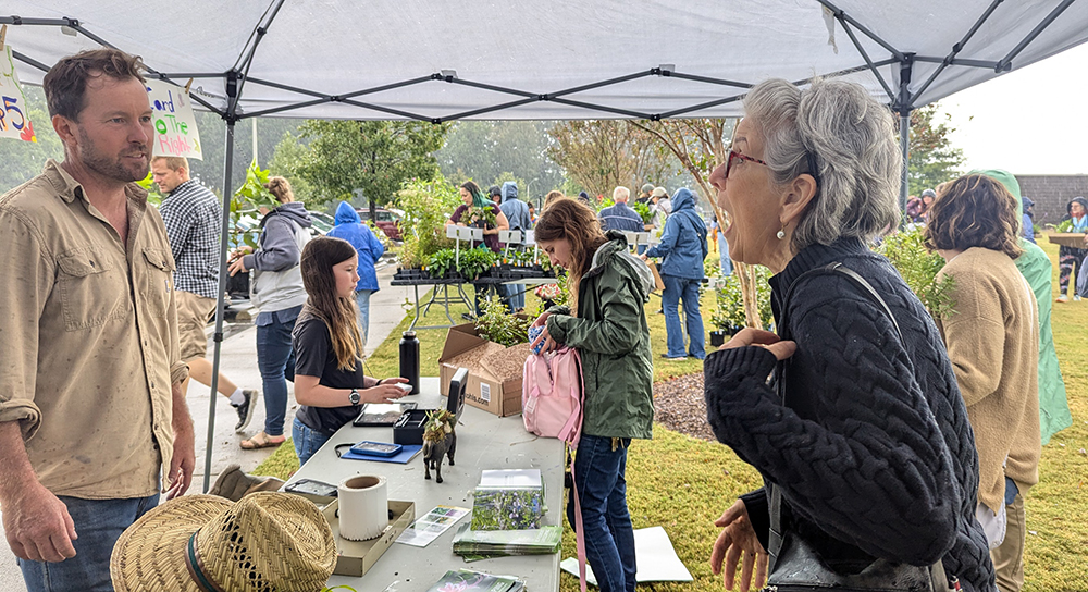 Grower Farrell Moose and his daughter assist customers at the Dutch Buffalo Farm. booth.