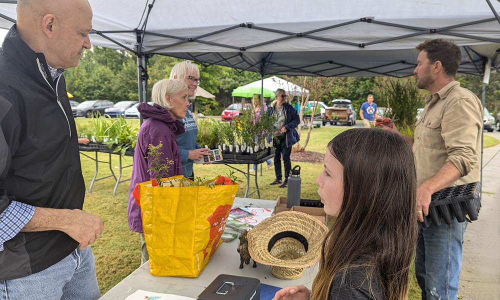 Grower Farrell Moose and his daughter assist customers at the Dutch Buffalo Farm. booth.