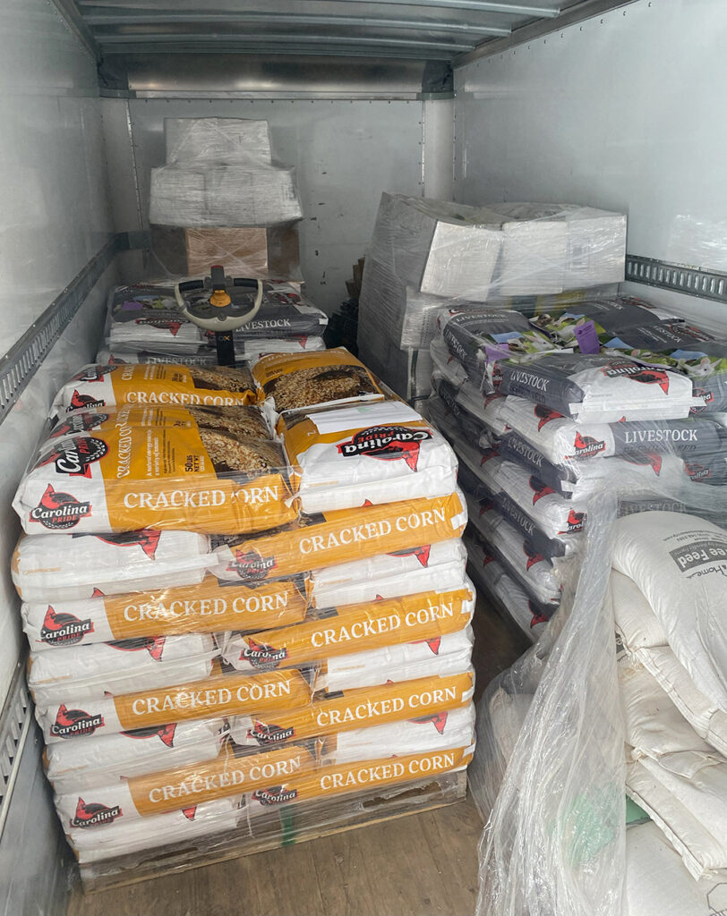 Livestock feed and fencing supplies from Country Farm & Home loaded on a truck for delivery to aid farmers in western NC. 